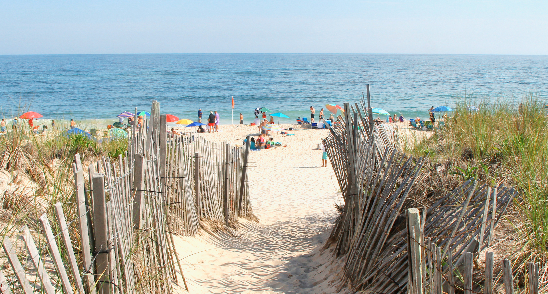 Sandy path through dune fencing leading to the ocean